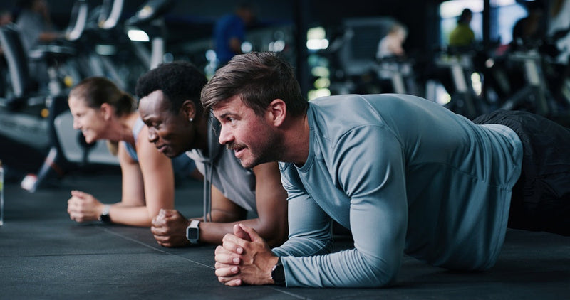 Personen machen Planks im Fitnessstudio